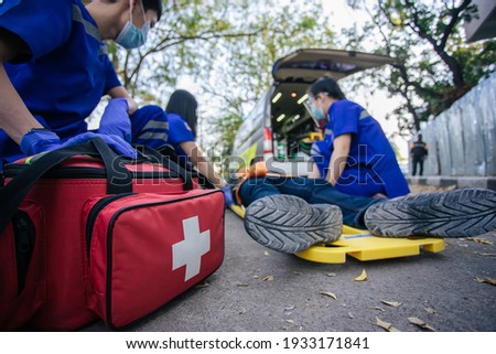 Selective focus is first aid bag. Team paramedic firs aid accident on road. Ambulance emergency service. First aid procedure. Royalty-Free Stock Photo #1933171841