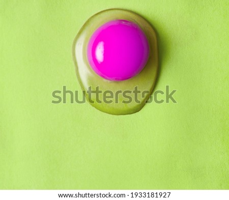 Photo of raw egg in abstract colors . Yolk on green background.