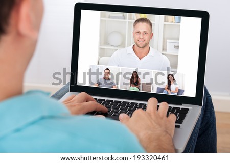 Man having video conference with friends on laptop at home Royalty-Free Stock Photo #193320461