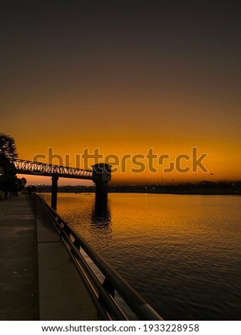 The sunset : place is sabarmati riverfront , Ahmedabad. This beautiful evening scene have the colours dull orange and black silhouette Royalty-Free Stock Photo #1933228958