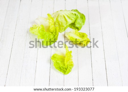 lettuce leaves on white wooden background