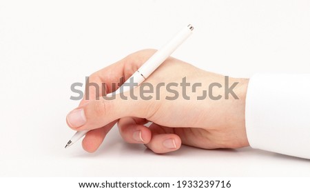 Doctors hand writing using a white pen, closeup, gesture isolated on white. Medical personnel, doctor holding a pen writing a prescription, signing a document, up close, prescribing abstract concept