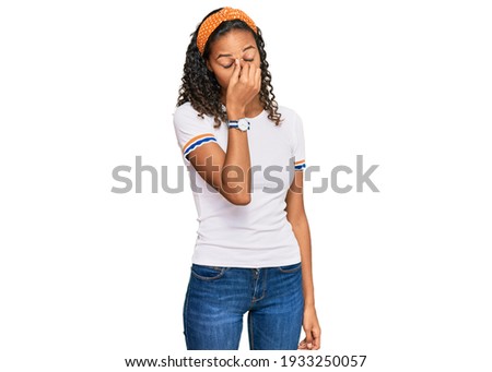 Young african american girl wearing casual clothes tired rubbing nose and eyes feeling fatigue and headache. stress and frustration concept. 