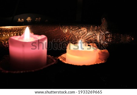 Candlelight illuminates the scabbard of an ancient Chinese sword. Selective focus. Dragon picture on sword
