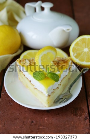 piece of lemon cake tart decorated with fresh lemon and mint