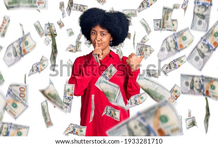 Young african american girl wearing casual clothes asking to be quiet with finger on lips pointing with hand to the side. silence and secret concept.
