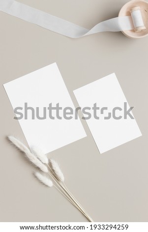 Wedding invitation stationery mockup with a satin tape and a lagurus decoration. Dimensions: 5x7", 6x4".