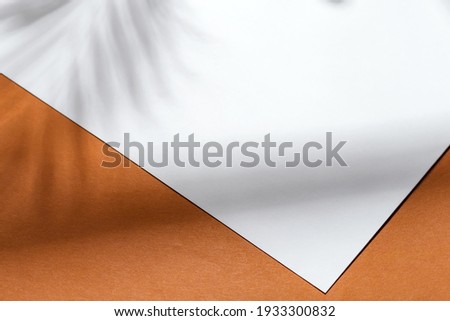 white paper note on brown background with shadow on brown background