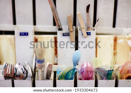 shelf with creative utilities like spoon and brushes