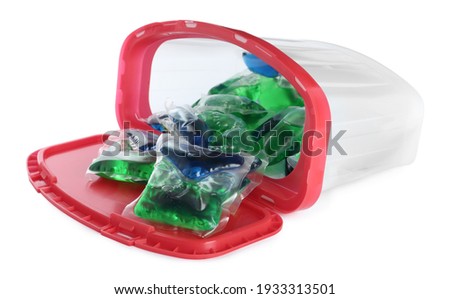 Overturned box with laundry capsules on white background