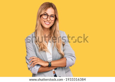 Beautiful blonde young woman wearing business clothes happy face smiling with crossed arms looking at the camera. positive person.  Royalty-Free Stock Photo #1933316384