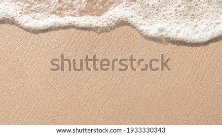Beach sand sea water summer background.
Sand beach desert texture.
White foam wave sandy seashore top view.