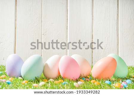 Easter Greeting card, invitation background. Easter Eggs In A Row on Spring Grass and White Wooden Background 