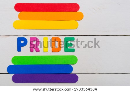 LGBTQ flag and the word pride. LGBT gay pride rainbow colored stripes symbol.