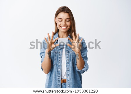Portrait of good-looking smiling woman showing plastic credit card, have bank account, standing in casual clothes against white background
