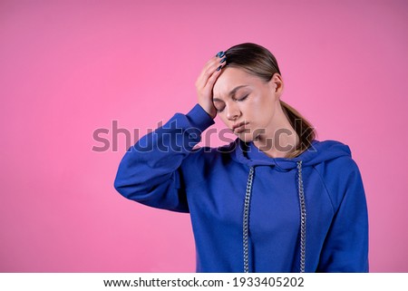 Tired, sick, emaciated girl, young sleepy woman suffering from headache, migraine, lack of sleep, holding her forehead with her hand. Insomnia, fever, health care concept. On pink isolated background Royalty-Free Stock Photo #1933405202
