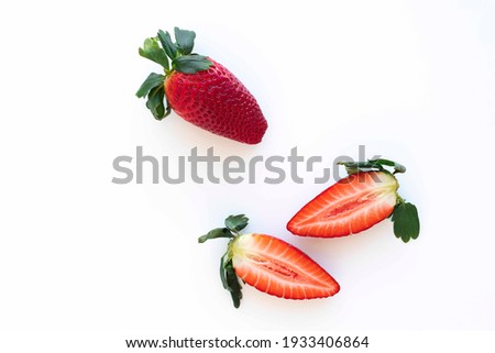 Large ripe strawberry, whole and cut in half close-up isolated on white background, space for text.