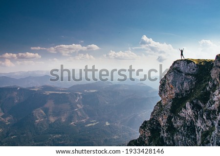 call of nature on the Ötscher mountain. The girl in black sportswear stretches on a rock massif. Dangerous place. View of the Austrian Alps. Royalty-Free Stock Photo #1933428146