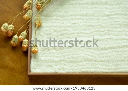 “Zen style” White sand sign board.
with Globe amaranth flower. 
  
blurred background soft focus image.