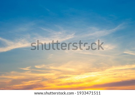 Beautiful sky painted by the sun leaving bright golden shades.Dense clouds in twilight sky in winter evening.Image of cloud sky on evening time.Evening sky scene with golden light from the setting sun Royalty-Free Stock Photo #1933471511
