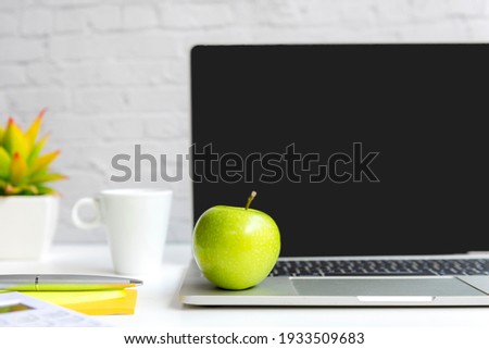 Healthy snack with working in office.  Green apple with laptop on white dress working.  Healthy Lifestyle Concept