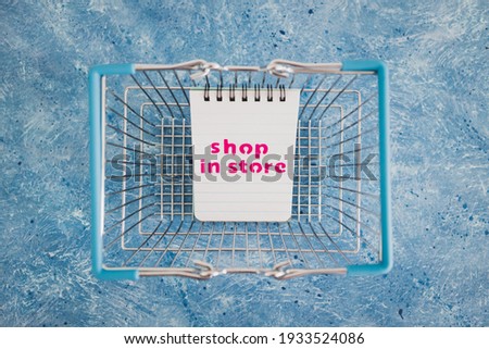 competition and retail industry conceptual image, shop in store text on notepad inside shopping basket