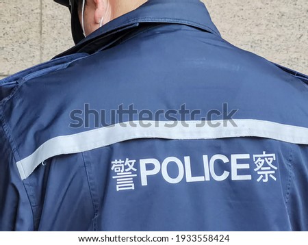 back of Police with face mask on Duty in Hong Kong Royalty-Free Stock Photo #1933558424