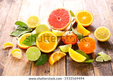 various citrus fruits on wood background Royalty-Free Stock Photo #1933569494