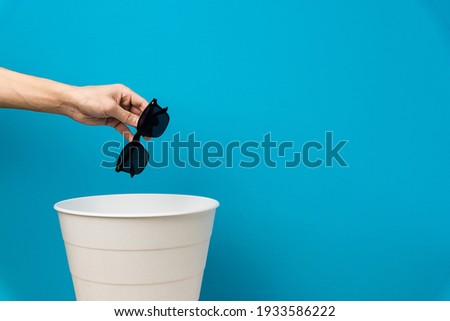 The black sunglasess is thrown into the trash for disposal and recycling Royalty-Free Stock Photo #1933586222