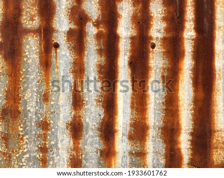 Full frame colorful of the rusty and worn metal exterior background texture. Vivid color shade of rusty corrugated iron metal fence pattern for work art.