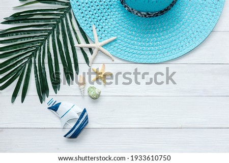 Summer Fashion tourism woman big hat and accessories to travel in the beach. Tropical sea. Unusual top view, wood white background. Summer and Trips Concept.
