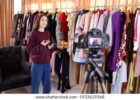 Young woman vlogger shooting clothing review video, using camera on tripod. Online sales business New sales concept. Online selling, work at  from home, business and technology concept