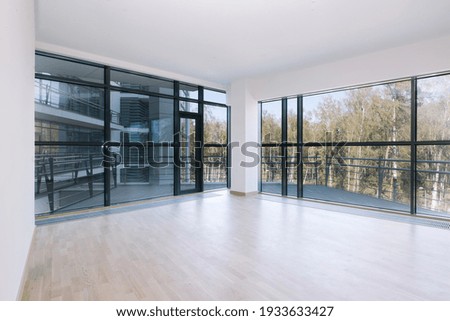 Empty room with big window in loft style. Clean and bright space for office. Real estate
