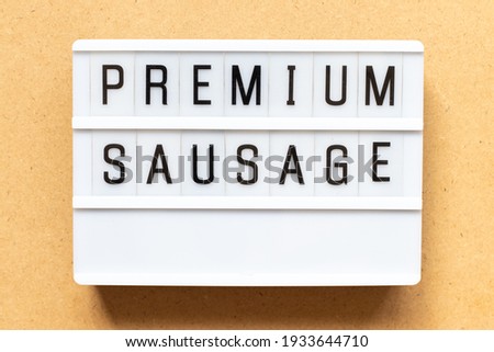 Lightbox with word premium sausage on wood background