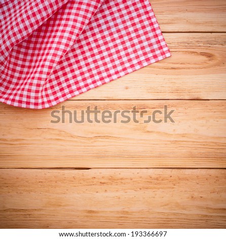 Pure notebook for recording menu, recipe on red checkered tablecloth tartan. Wooden table close up view from top 