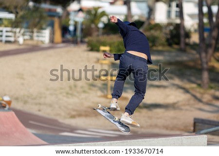 young man jumping on skateboard in skatepark