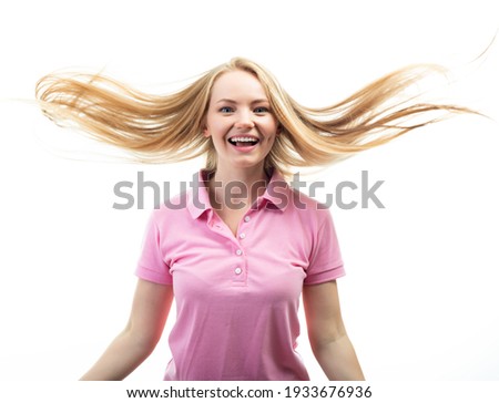 Happy smiling excited comical surprised young charming woman with long flying blond hair over white background. 