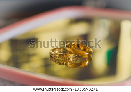 Duo Golden wedding ring on color background.