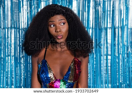 Portrait of attractive girlish luxury wavy-haired girl clubber pouted lips isolated over blue tinsel curtain background