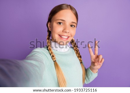 Photo of little funny lady beaming smile show v-sign take selfie wear green sweater isolated violet background