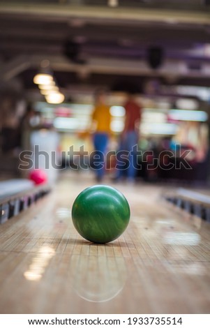 Young couple having fun in bowling alley.  Focus is on bowler. 