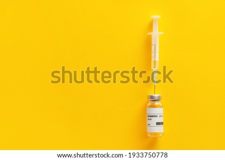 Vaccine for immunization against COVID-19 and syringe on color background