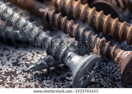 A handful of old self-tapping screws covered in dirt and rust. Screws macro photo. Construction abstraction. Industrial background.