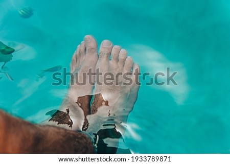 beautiful bright blue water, texture of the water surface of blue color, male hairy legs in the water
