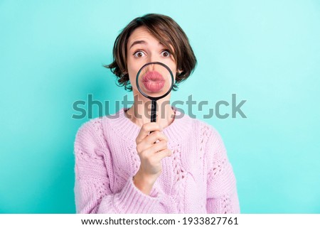 Photo of sweet funny young woman wear violet sweater enlarging loupe pouted lips isolated turquoise color background
