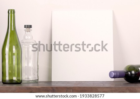 picture frame empty wine bottle on wooden table