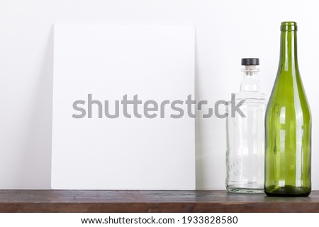 picture frame empty wine bottle on wooden table