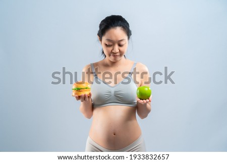 Asian pregnant woman choose healthy food or junk food