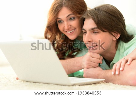 Close-up portrait of young couple with laptop at home