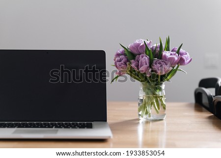 Workplace at home office with laptop and tulips flowers. 8 march. springtime. slow living. mindful work life balance. woman at work